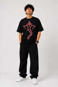Black oversized graphic T-shirt from the StitchVaults™ GANESHA LEGACY™ Collection featuring a minimalist red neon line art illustration of Lord Ganesha with a sacred tilak design on the front.