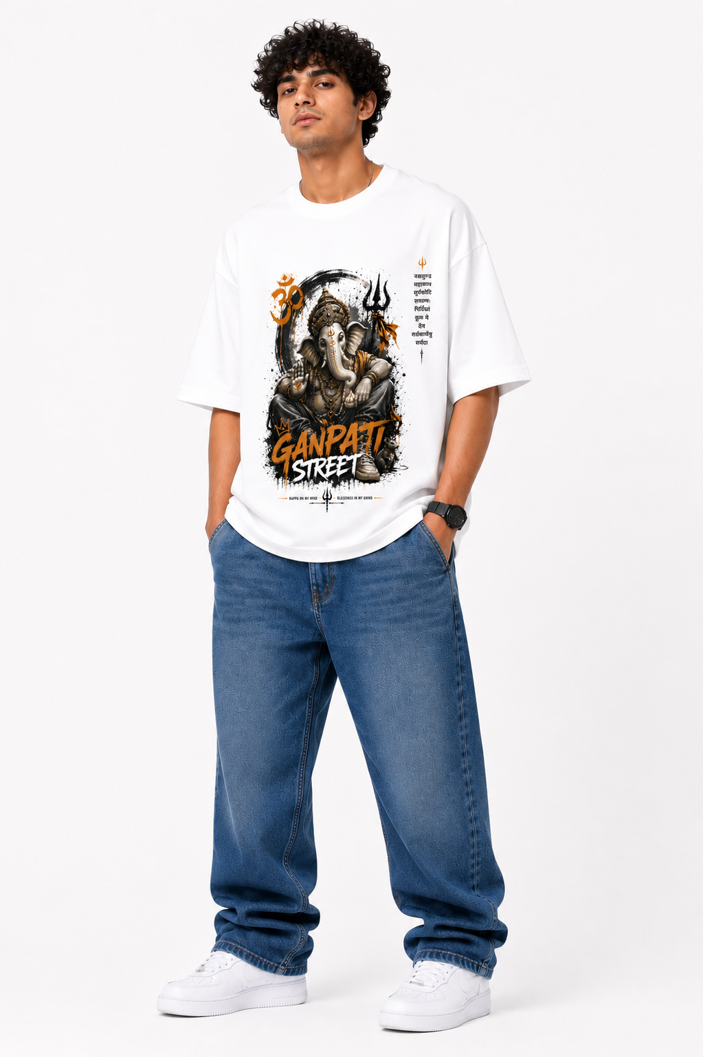 White oversized graphic T-shirt from the StitchVaults™ GANESHA LEGACY™ Collection featuring an artistic Lord Ganesha streetwear illustration with Om symbol, Trishul, Sanskrit text, and bold Ganpati Street typography.