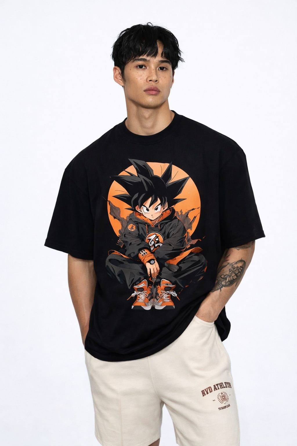Front view of a white oversized t-shirt featuring a stylized anime illustration of Goku sitting in streetwear clothing against an orange circular background.