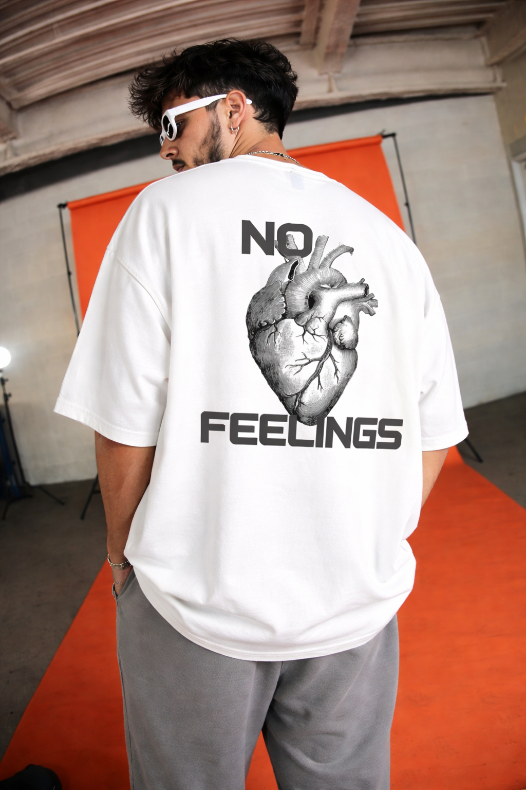 Indian male and female models wearing white oversized t-shirt with No Feelings heart graphic streetwear style