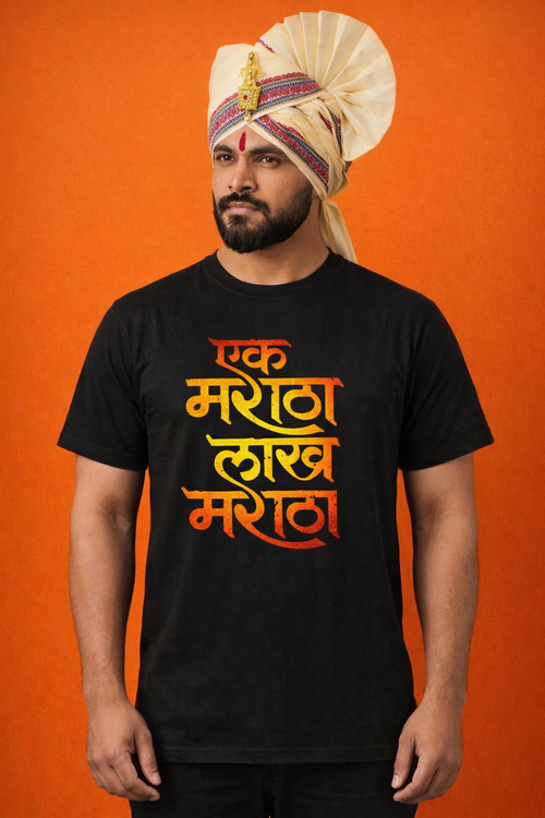 A bearded man wearing a traditional cream-colored Maratha Pheta (turban) with a gold brooch and a black T-shirt featuring the Marathi slogan "Ek Maratha Lakh Maratha" in orange and yellow gradient text against an orange background.