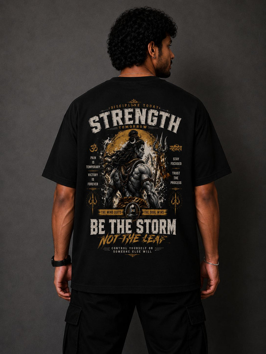 Person wearing a black t-shirt with shiva strength graphic design and text on the back against a dark background
